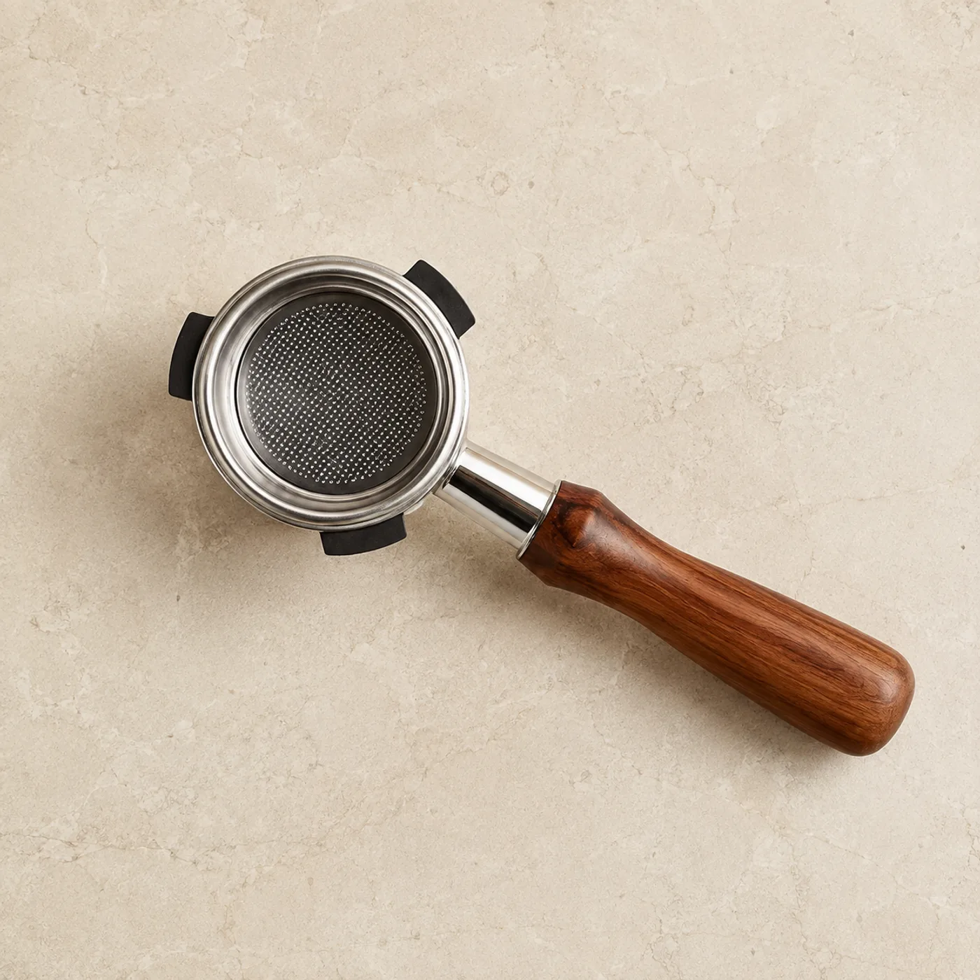 Puckwell bottomless portafilter with rosewood handle resting on a stone counter, seen from above